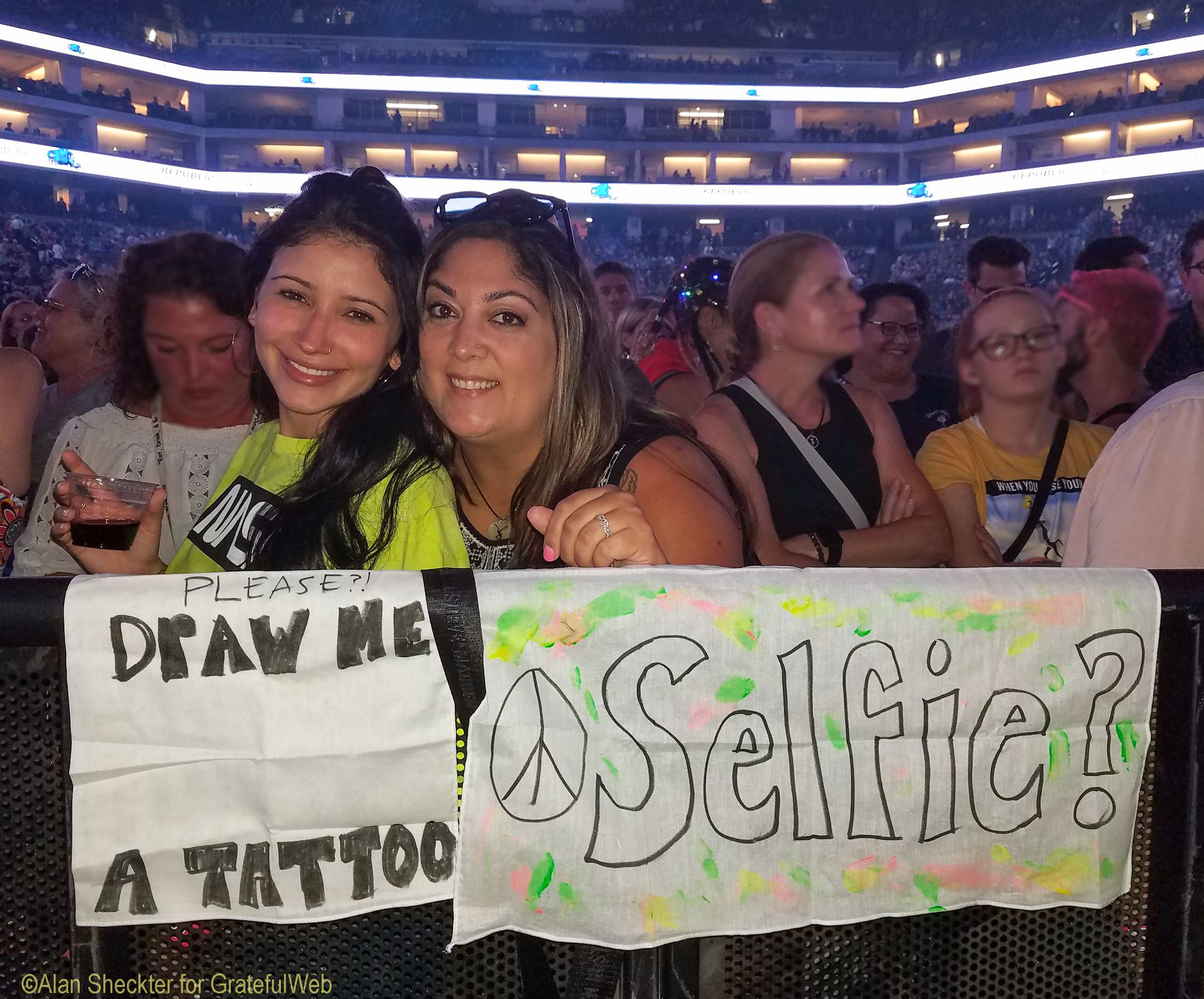 Perched in front of the stage, Emily Rivera (right) and her friend Dee, tried to entice Dave Matthews, who is also a visual artist, to come down and hang