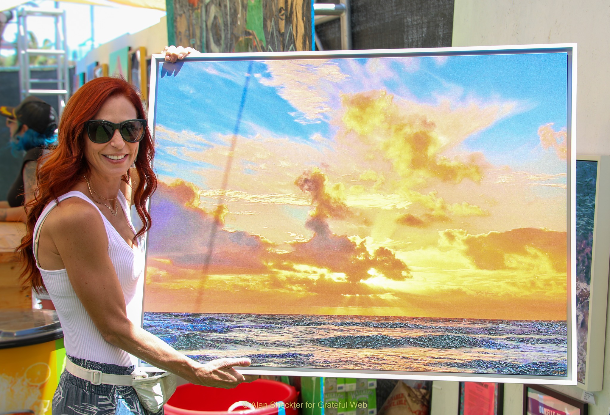 Danielle Rush poses with one of her illuminated “makeup on canvas” artworks on which makeup adds extra sparkle to a photograph