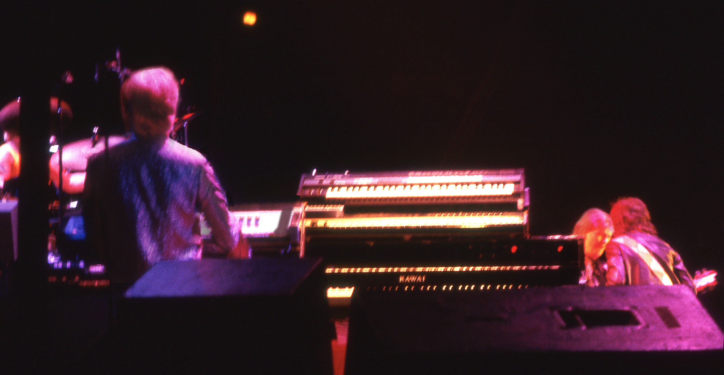 Yes keyboardist Tony Kaye, with Chris Squire and Trevor Rabin huddling, live in 1984 | Photo: Sam A. Marshall | Cincinnati OH