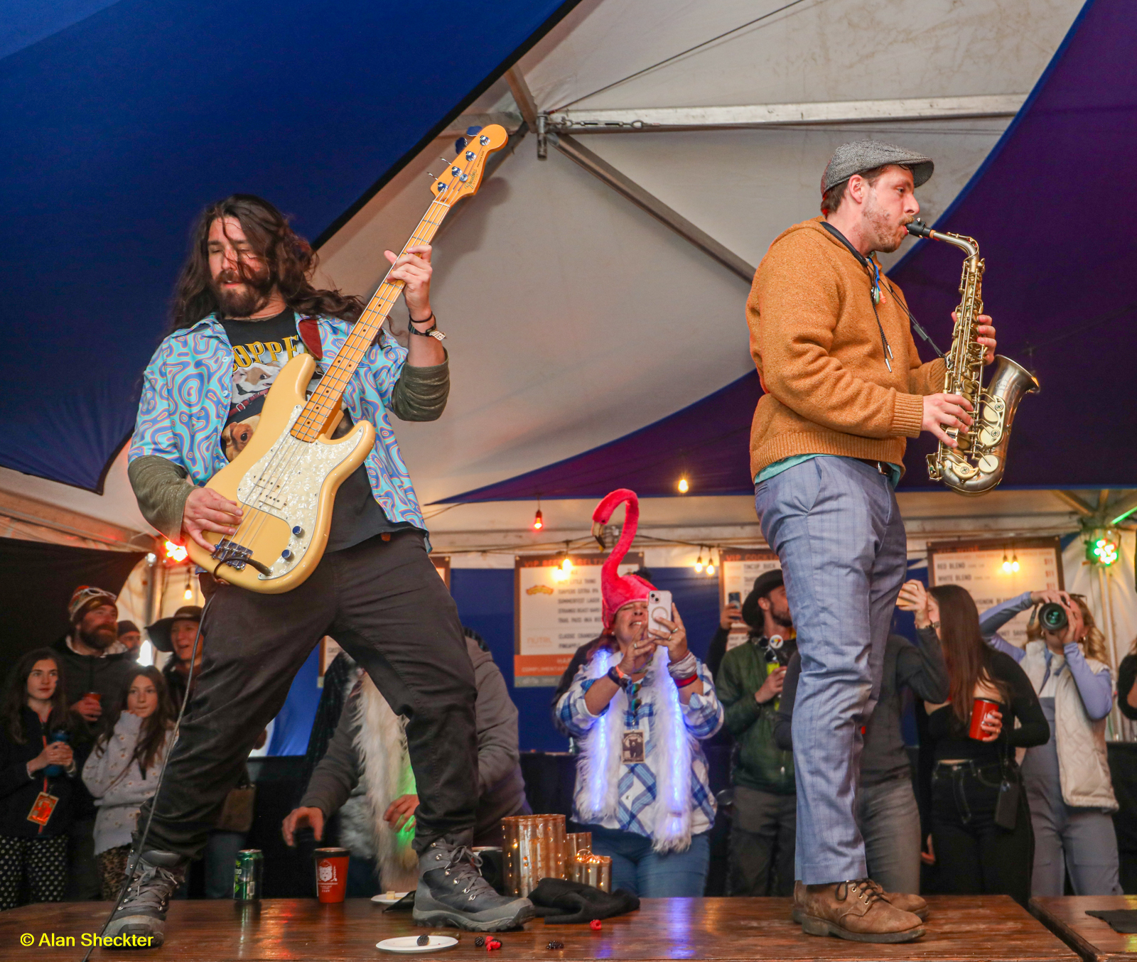 Boot Juice’s Brett Worley (left) and Caleb Sanders up on the tables in the VIP tent early Saturday evening