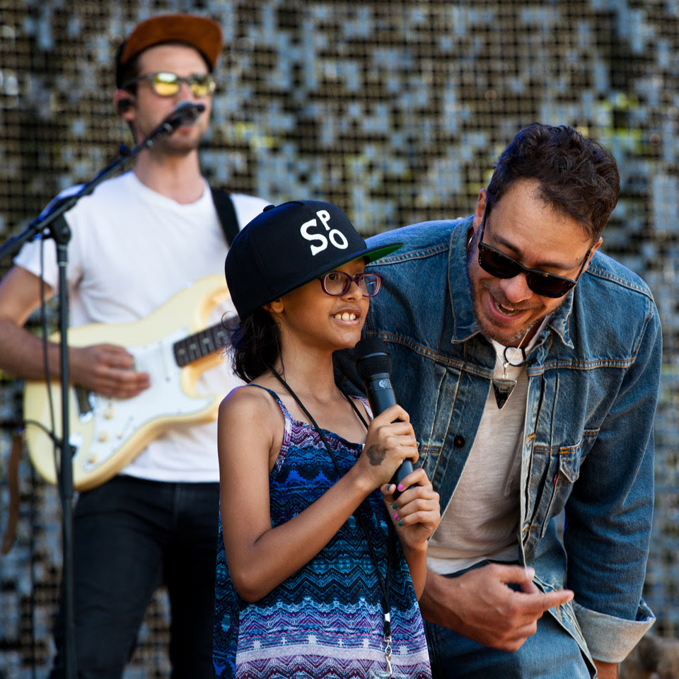 Amos Lee (right) is joined on stage by Melodic Caring Project rockSTAR Maya at a concert at Seattle’s Woodland Park Zoo in 2019