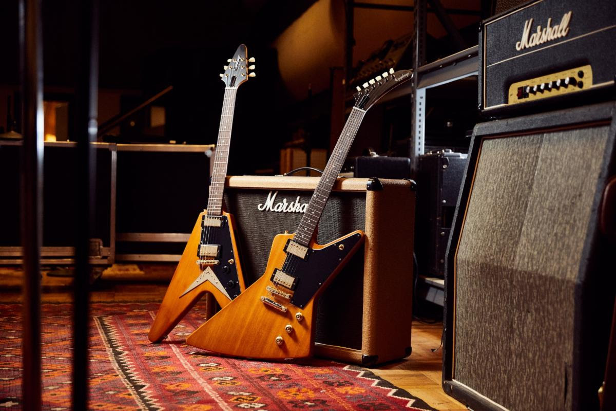 Above (L-R): the Epiphone 1958 Korina Flying V and Explorer with black pickguards.