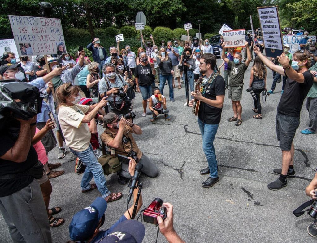Joe Troop's song to save the USPS goes viral at North Carolina protest outside DeJoy's mansion