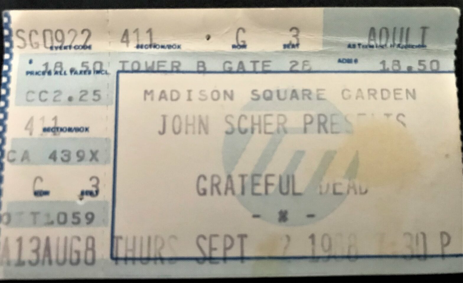 Ticket stub for a Madison Square Garden event, reading 'MADISON SQUARE GARDEN' and 'JOHN SCHER PRESENTS' with a large blue border and partial venue details visible.