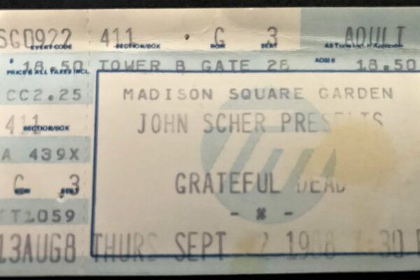 Ticket stub for a Madison Square Garden event, reading 'MADISON SQUARE GARDEN' and 'JOHN SCHER PRESENTS' with a large blue border and partial venue details visible.