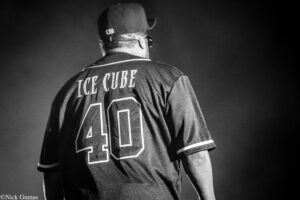 Back view of a person wearing a black Ice Cube jersey with large white numbers, seen from behind (black-and-white photo).