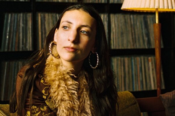 Portrait of a woman with a scarf in a cozy room; banner text reads 'Stella Prince' and 'For What It's Worth'.