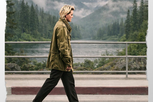 Person walking along a roadside railing by a misty mountainous lake, wearing an olive jacket and dark pants; text 'LIFE ON THE RUN' appears in the top-right.
