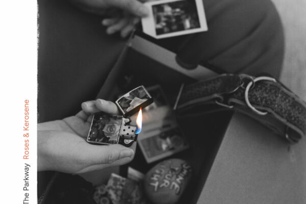 Close-up of hands lighting a photo with a lighter, surrounded by other photos and keepsakes.