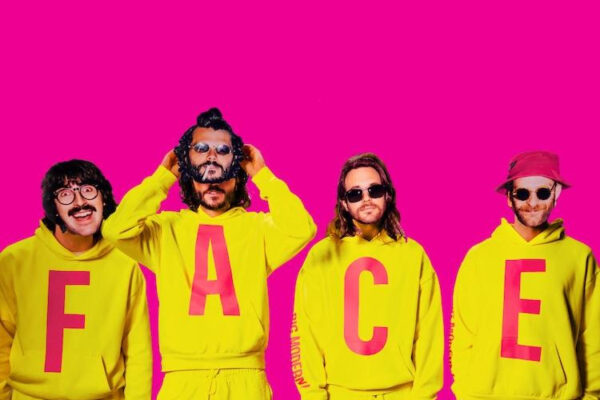 Four men in neon yellow outfits with large pink letters forming 'FACE' on a bright magenta background.