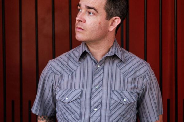 Portrait of Kyle LaLone in a gray striped shirt against a red fence, with the text 'Kyle LaLone Make My Own Way'.